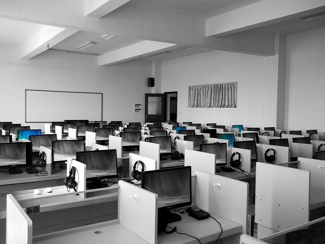 UK learners studying IT in a modern classroom with laptops and lab equipment