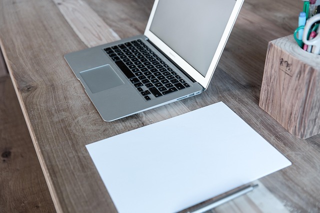 UK IT learner using laptop with study checklist and notebook